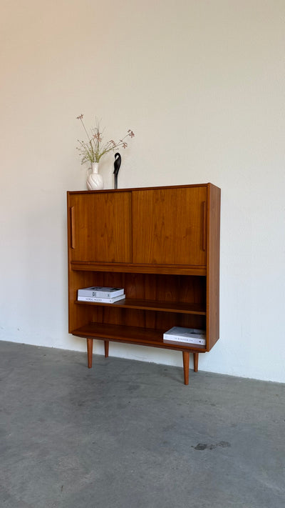 
                  
                    Vintage teak boekenkast met schuifdeuren
                  
                