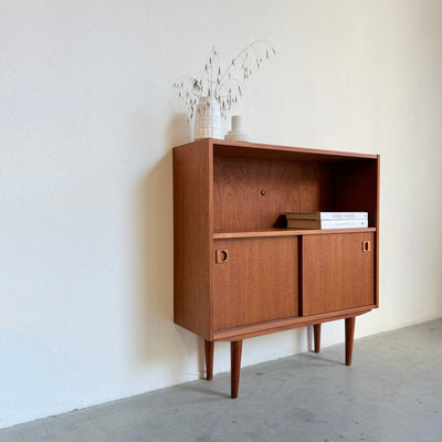 
                  
                    Deens klein boekenkastje met schuifdeuren
                  
                